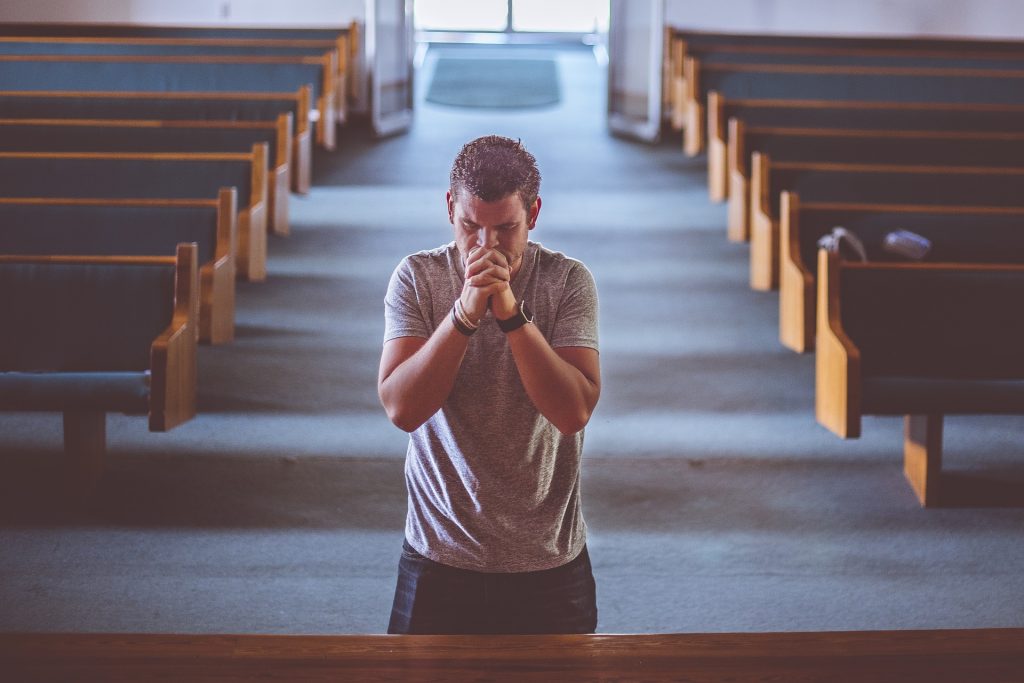 man praying empty pews